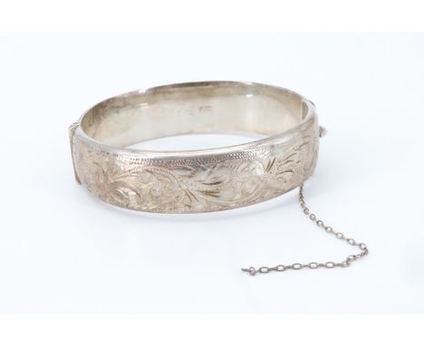 An Elizabeth II silver bangle, bright cut decorated, hinged with a box clasp, bearing '12-12-74' engraved internally,  Birmin