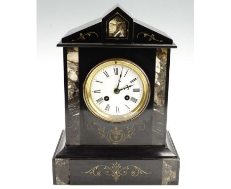 An early 20th Century black slate mantle clock, having a French drum movement with a pendulum escapement striking on a bell, 