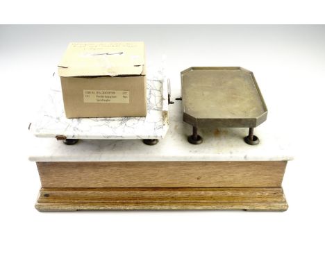 A set of early 20th Century shop counter balance scales, having an oak case with a marble top, a brass weights platform and a