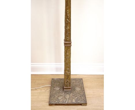 A 1930s brass standard lamp,  formed from embossed brass, decorated with grape and vine, covering a tapering square section c