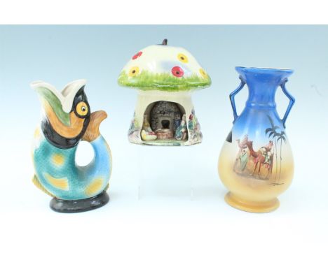 A Royal Winton glugle jug in the form of a fish, together with a ceramic nursery lamp in the form of a toadstool home and one