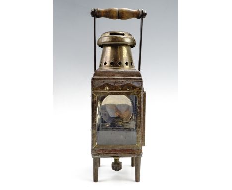 A 1930s brass and steel two glass railway lamp, having a fixed handle and a removable square tinplate reservoir, raised on fo