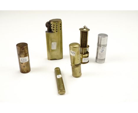 A small group of vintage brass wheel cigarette lighters, including a novelty miners lamp form gas lighter, two "lipstick" lig