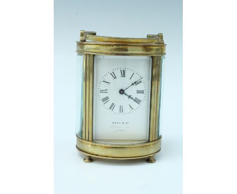 A Kuss and Co. early 20th Century oval bodied brass carriage clock, having a key wound movement with a white dial bearing ret