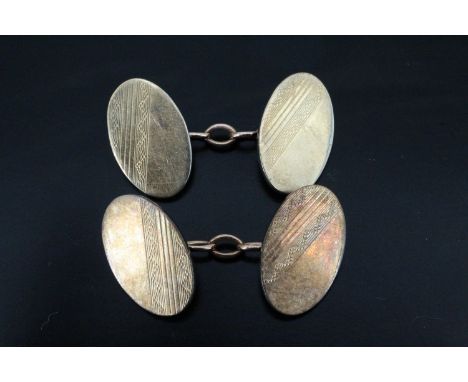 A pair of white and yellow metal cufflinks, engine turned oval fronts, marked "9ct gold and silver", 10.7 g