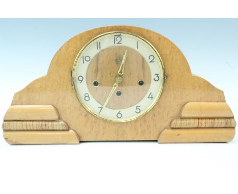 A 1950s Moderne bird's eye maple mantle clock, having a German movement with a pendulum escapement, striking and chiming on a
