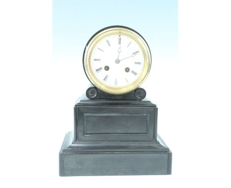 An early 20th Century black slate mantle clock, having a French drum movement with a pendulum escapement, striking on a bell,