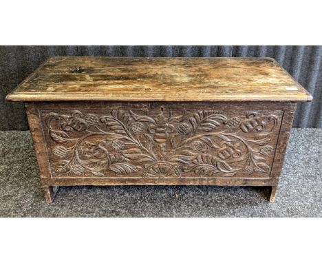 A 19th century oak coffer with a front carved foliate panel. [49 x 101.5 x 44cm]