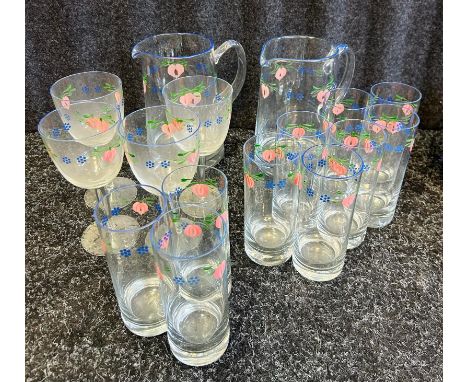 A glass and jug set with blue painted rims and hand painted design.