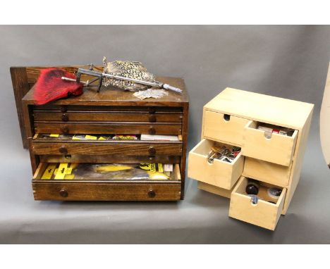A fly tying kit to include an oak case of drawers containing various hackles, deer fur, feathers etc, a six drawer chest cont