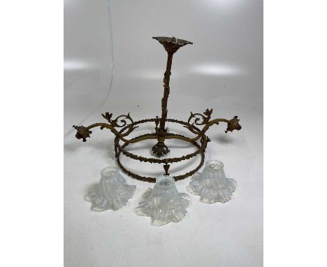 An early 20th century gilt light fitting with three glass shades.