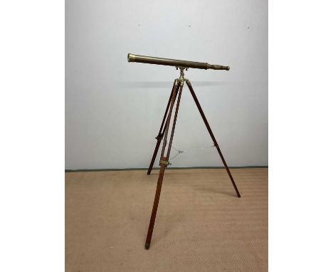 A reproduction brass telescope on tripod stand, height of fully extended tripod 132cm, length of telescope 100cm.