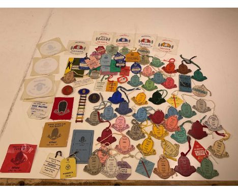 A collection of Bugatti Owners Club badges and ephemera including enamel badges from 1965 to 1973, windscreen stickers, a clo