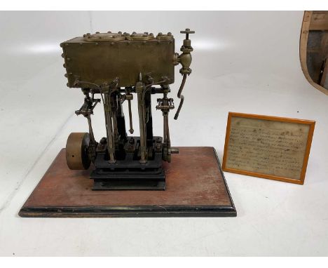 A scratch built scale model twin cylinder marine engine mounted on a wooden base, with accompanying note, height 42cm.