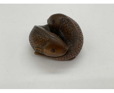 A contemporary Japanese boxwood netsuke modelled as two fish, signed, length 40mm.