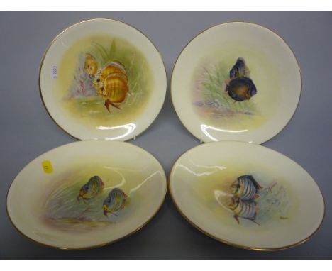 A SET OF FOUR PLATES, decorated with fish by E R Booth 