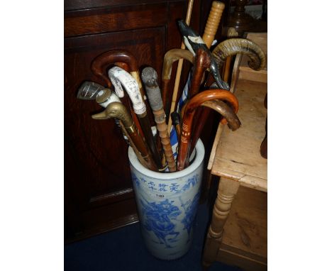 BLUE AND WHITE CERAMIC STICK STAND, containing a quantity of walking sticks etc 