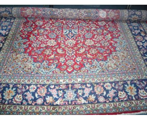 RED AND BLUE GROUND PERSIAN HAND WOVERN CARPET, approximate size 435cm x 302cm, Made in Iran, label attached 