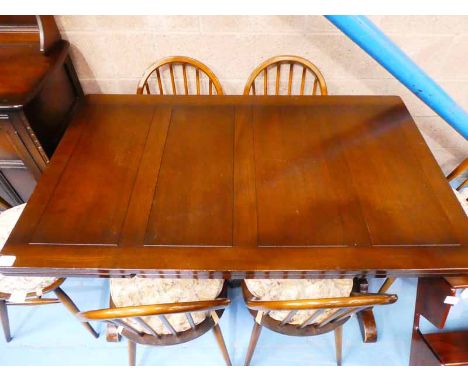 An Ercol dark stained draw leaf Dining Table and six spindle back chairs 