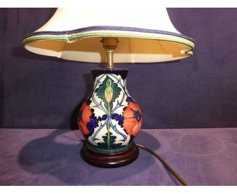 A modern Moorcroft Pottery Table Lamp, tubeline decorated with Poppies and Thistles on a cream ground, supported on a circula