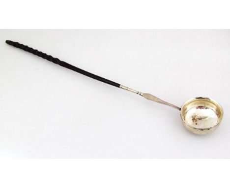 An 18thC toddy ladle, with plain bowl, partially turned horn handle and metal tip end, initialled to the stem, 39cm wide.