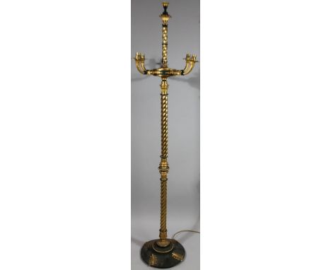 A gilt metal and ebonised standard lamp, in the Empire style, with five fitted branches, on a spirally turned column and circ