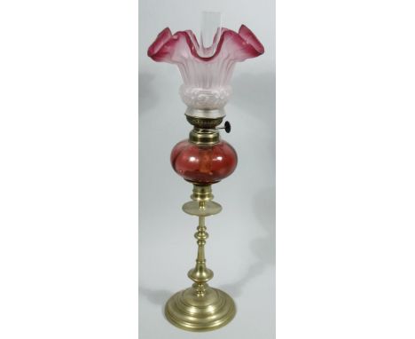 A late 19thC cranberry and brass oil lamp, of small proportion, with clear funnel, frosted clear and pink glass textured shad