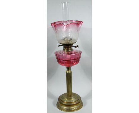 A Victorian cranberry glass and brass oil lamp, with Best markings, with plain funnel, frosted clear and cranberry glass flor