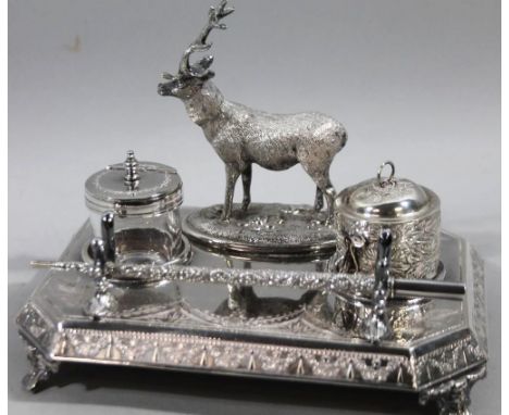 An early 20thC silver plated inkstand, headed by a figure of a stag on canted rectangular base with a bright cut repeat flora