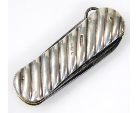 A silver handled folding knife, with double blade and button hook, with engine turned body (when closed), 6cm wide.