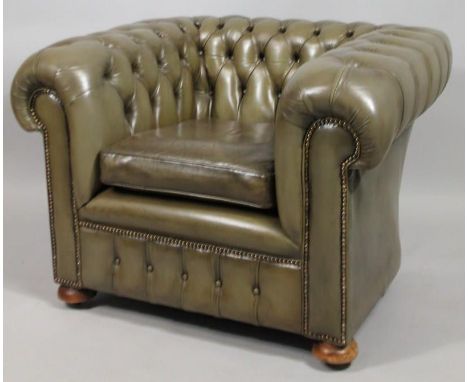 A green leatherette Chesterfield type tub shaped chair, with a button back and padded loose cushion. 