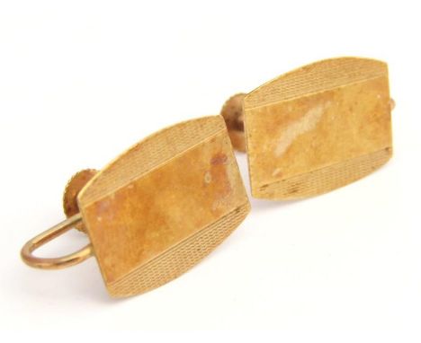 A pair of early 20thC clip cufflinks, each of shield shape outline, partially engine turned with articulated ring backs, yell
