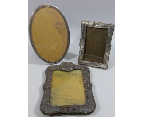 Three various silver photograph frames, to include an oval example with engine turned repeat design initialled P.K, with oak 