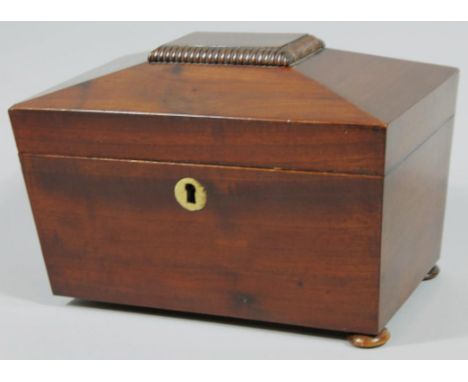 An early 19thC mahogany sarcophagus shaped tea caddy, of rectangular outline, the hinged lid revealing two sectional compartm