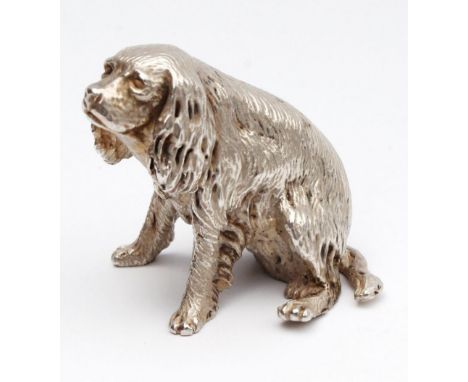 An Elizabeth II silver novelty seated dog charm ornament, possibly a spaniel, Sheffield 1997, 4cm high, 2½oz.