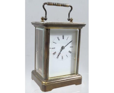 A 20thC brass cased carriage clock, the four sectional glass case with swing handle, visible movement and 5cm wide back plate