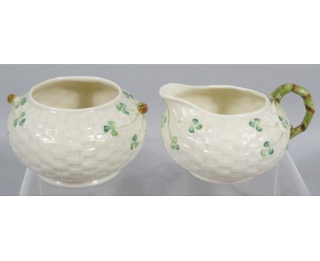 A modern Belleek two piece tea service, comprising of a sugar bowl and milk jug, 7cm high, each with three leaf clover decora