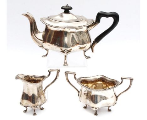 An Edwardian silver three piece bachelor's style tea service, comprising tea pot, 16cm high, with ebonised knop and shaped ha