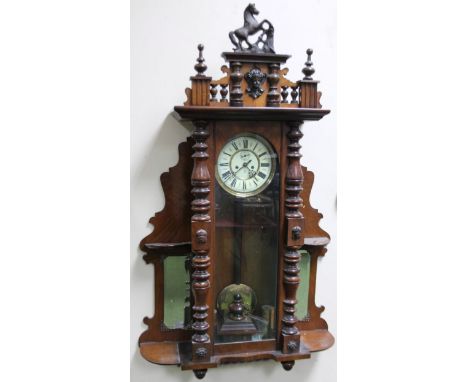 A Gustav Becker late 19thC Vienna wall clock, in walnut case, the shaped pediment with composition horse finial above an enam