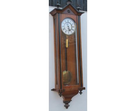 A late 19thC/early 20thC Vienna type walnut and ebonised wall clock, with an arched crest and enamel dial decorated with Roma