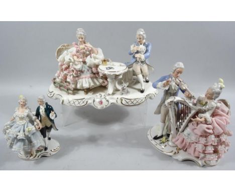 A 20thC Dresden porcelain group of a lady and gentleman, each seated and dressed in finery taking tea, on a gilt highlighted 