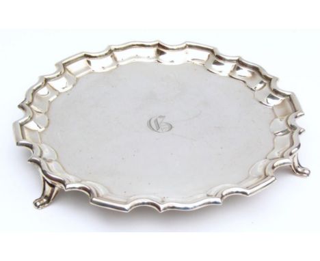A George V silver card waiter, by Charles Boyton & Son, of pie crust outline on triple scroll supports, initialled to the cen
