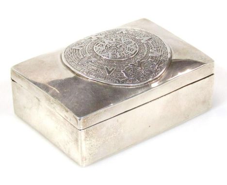 A 20thC ring casket, of rectangular outline, the shaped lid set with an Inca style roundel with plain interior, Mexican white