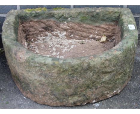 An early 20thC D-end stone trough, of shaped outline, with outlet hole to the interior, 20cm high, 51cm wide, 41cm deep.