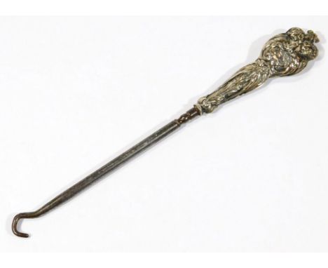 A George V silver and base metal button hook, with typical outline, with repousse decorated scroll handle, Chester 1920, 18cm