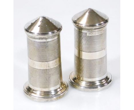 A 20thC silver part cruet, comprising of salt and pepper pots, each of cylindrical part engine turned outline on circular fee