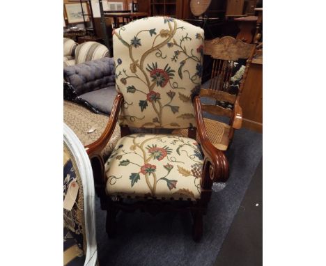 A stained wood large elbow chair having scrolled arms, stretchers and legs with tapestry upholstery
