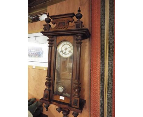 An Edwardian walnut cased Vienna style wall clock with enamel dial and Roman numerals 