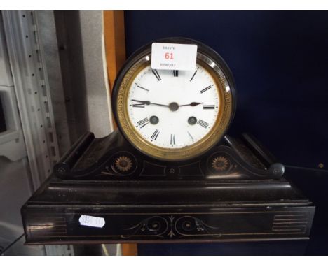 A Victorian floral carved slate mantle clock with circular Greek key bezel, enamel dial with Roman numerals