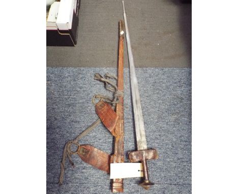 A 19th C Tuareg Ctakouba double bladed sword with leather covered handle and guard and stepped pommel with moulded leather sc